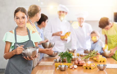 Iinterested tween girl attending group culinary classes for childrenの写真素材