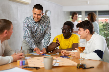 Positive man playing board game with male friendsの写真素材