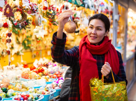 Woman with a Christmas tree toy in her hand buys decorations for new yearの写真素材