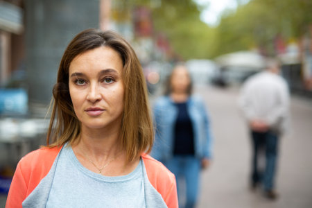 Portrait of brown-haired woman walking along city streetの写真素材
