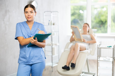 Young female doctor making notes in medical roomの写真素材