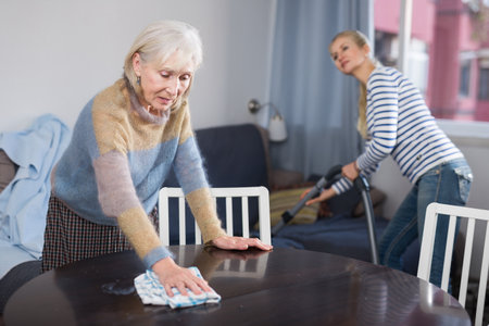 Woman cleaning table with rag at homeの写真素材