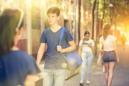 Teenager walking along city street on summer dayの写真素材