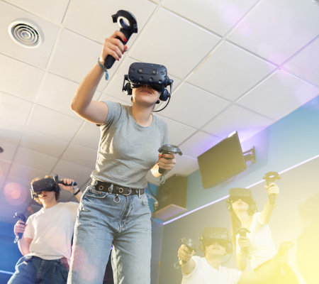 Emotional young woman in VR headset immersed in virtual game
