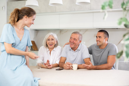 Family of four sits at table and talking