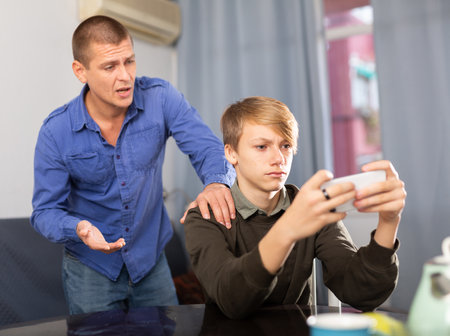 Portrait of angry father quarreling with teenage sonの写真素材