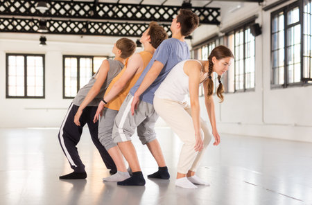 Teenagers training contemporary dance at studio