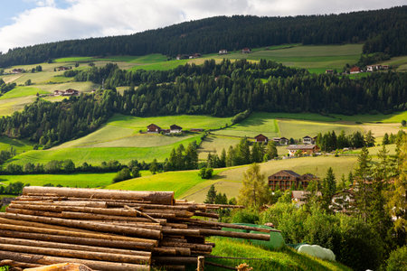 Snapshot of pile of logs neatly stacked on picturesque hill in Val di Funes region, Dolomites.の写真素材