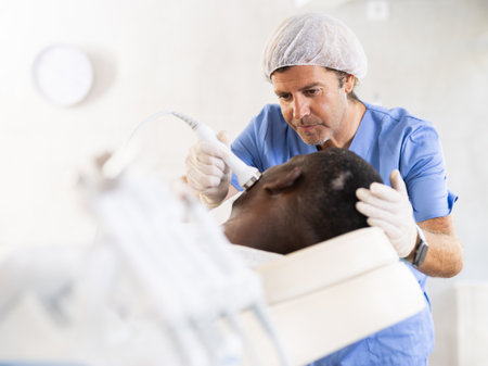 Professional aesthetician administering high frequency ultrasound facial procedure on manの写真素材