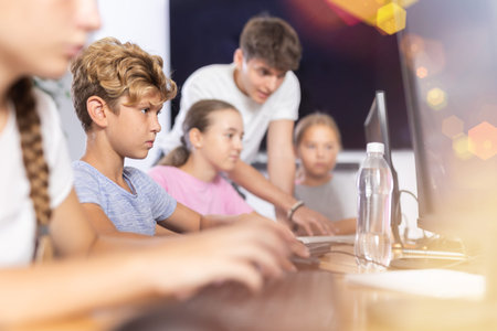 Preteen boy working with computer programs in training room