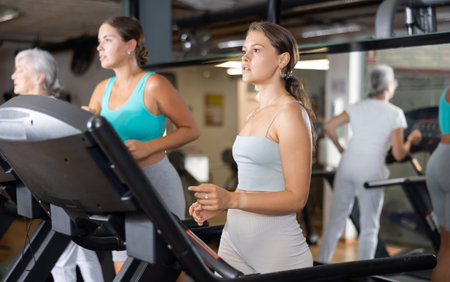 Girl in sportswear are running on treadmillの写真素材