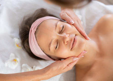 Young woman getting facial massage in salonの写真素材