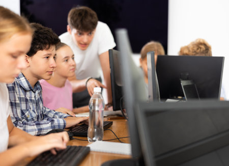 Boy student learning to work on computer in classroomの写真素材