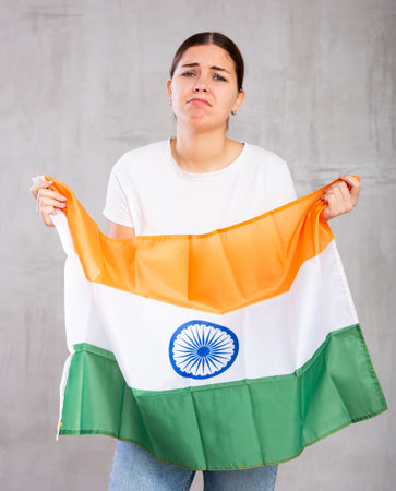 Sad young woman holding India flag