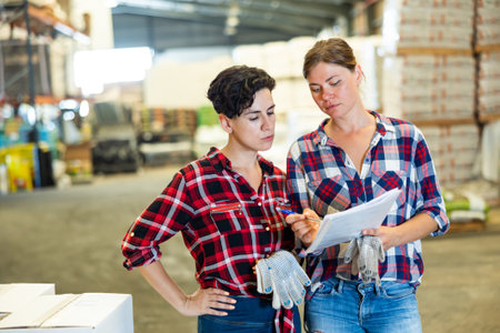 Female warehouse owner and manager keep track of products in warehouseの写真素材