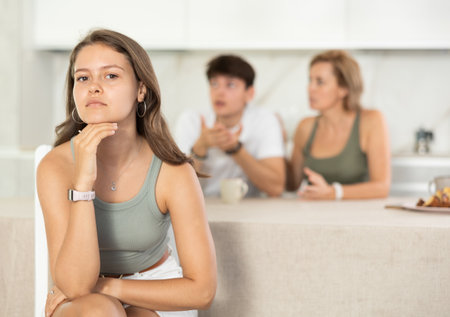 Mother-in-law and son scold young daughter-in-law in home kitchenの写真素材