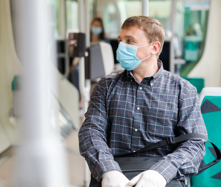 Man in medical mask riding city busの写真素材