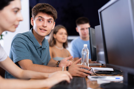 Cheerful interested guy using computer in student library