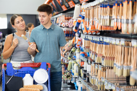 Young married couple buyer paint brushes together in hardware storeの写真素材