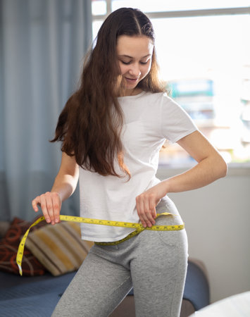 Portrait of woman taking measurements of bodyの写真素材
