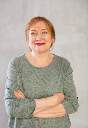 Older woman standing proudly with happy confident grinの写真素材