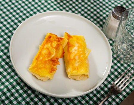 Pancakes stuffed with sweet berry chocolate filling are served with cup of hot green tea