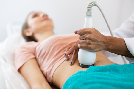 Cosmetologist making ultrasound lifting procedure in abdominal zonesの写真素材