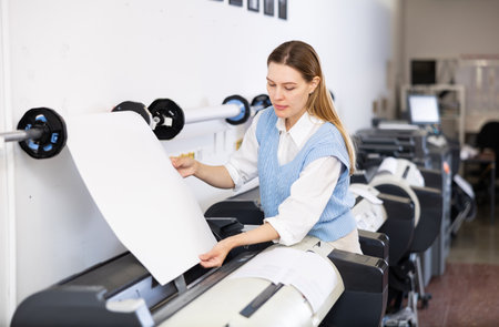 Print worker controlling printing process on modern offset machine in print shopの写真素材