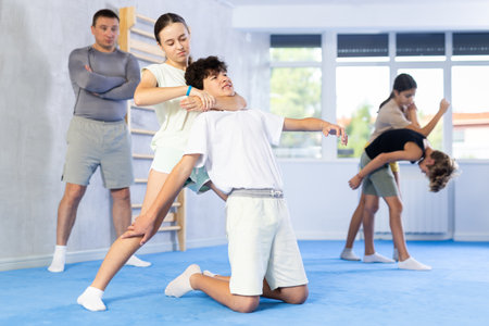 Preteen children pairs learning strength self-defense in gymの写真素材