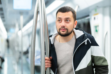 Portrait of male passenger with luggage in subway carの写真素材