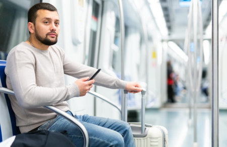 Male passenger in casual clothing talking on mobile phone in subwayの写真素材