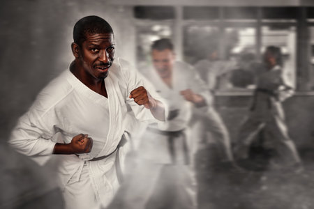 Two men practicing punches during karate classes in gymの写真素材