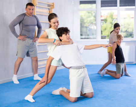 Boy and girl train to perform defense of strangling opponent, while learning self-defenseの写真素材