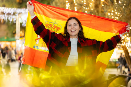 Happy girl with Spanish flag in street Christmas fairの写真素材