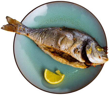 Dorada fish served on plate with lemon