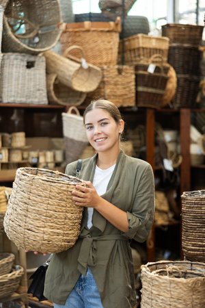 Girl looks at wicker basket in store.の写真素材