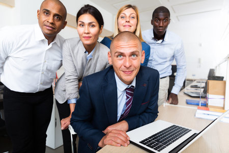 Portrait of happy cheerful positive successful multinational business group in room