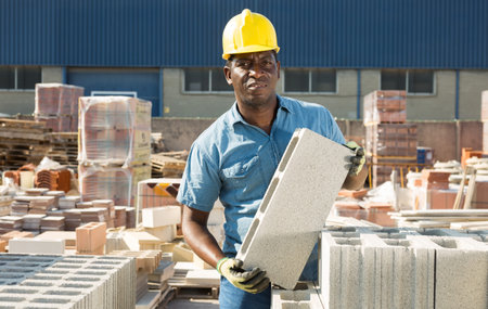 man is checking quality of bricks in the open area of a construction store