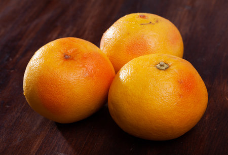 Whole pomelos on wooden tableの写真素材