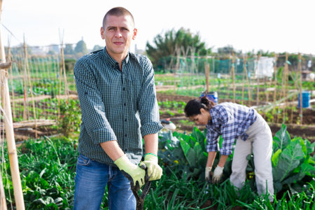 Adult european man gardener holding shovel in garden