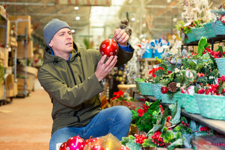 Man choosing christmas decorations in storeの写真素材
