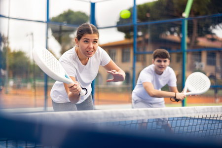 Young sporty couple playing paddle tennis outdoors