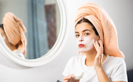 Young woman makes a cosmetic face maskの写真素材