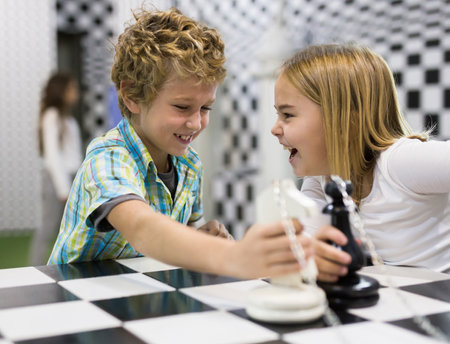 Tweenagers solving conundrum in lost room designed as chessboardの写真素材