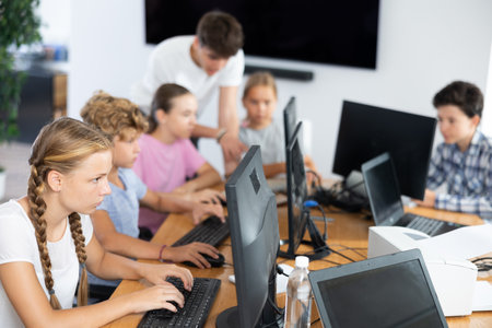 Preteen girl working with computer programs in training roomの写真素材