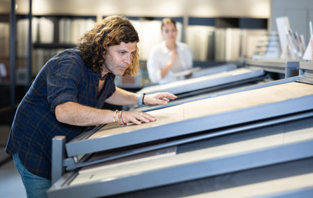 Handsome man customer choosing ceramic tile at building materials shop