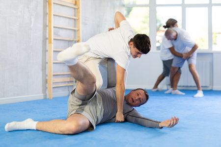 Judo lessons - young guy makes power throw during judo or sambo classesの写真素材