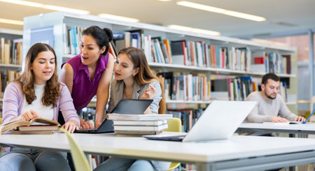 Three young women preparing for exams together in public libraryの写真素材