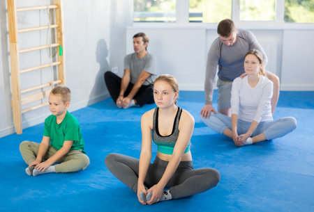 Big family before training martial arts performs stretching butterflyの写真素材