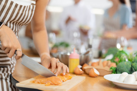 Young woman preparing chicken at master classの写真素材